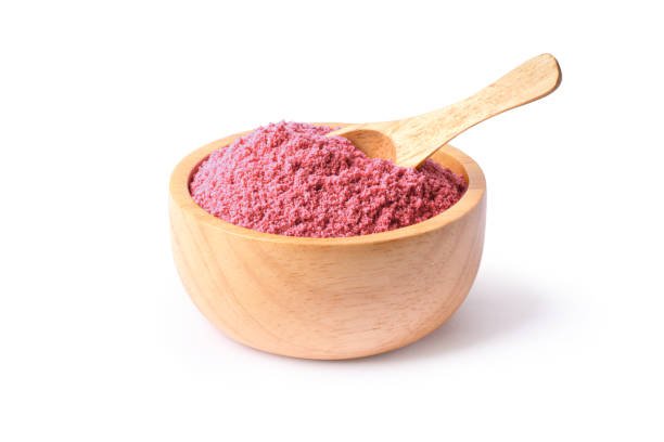 Bio fruit protein pink powder in wooden bowl isolated on white background.